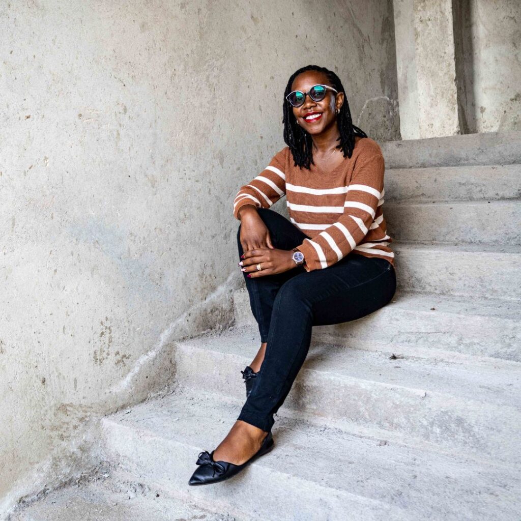Judith Wanja (the lead architect at Guarcha Architects, a leading architecture firm in Nairobi) sitting on a staircase in a house under construction