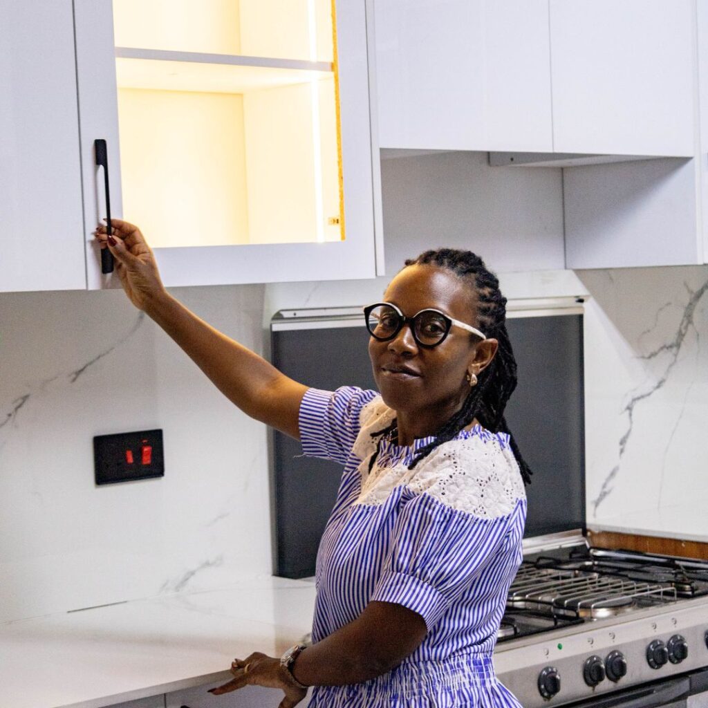 Wanja Githongo, lead architect at Guarcha Architects opening a cabinet in a kitchen she has designed.