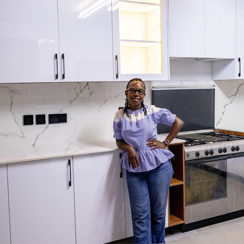 Wanja Githongo, lead architect at Guarcha Architects leaning on a cabinet in a kitchen she has designed.